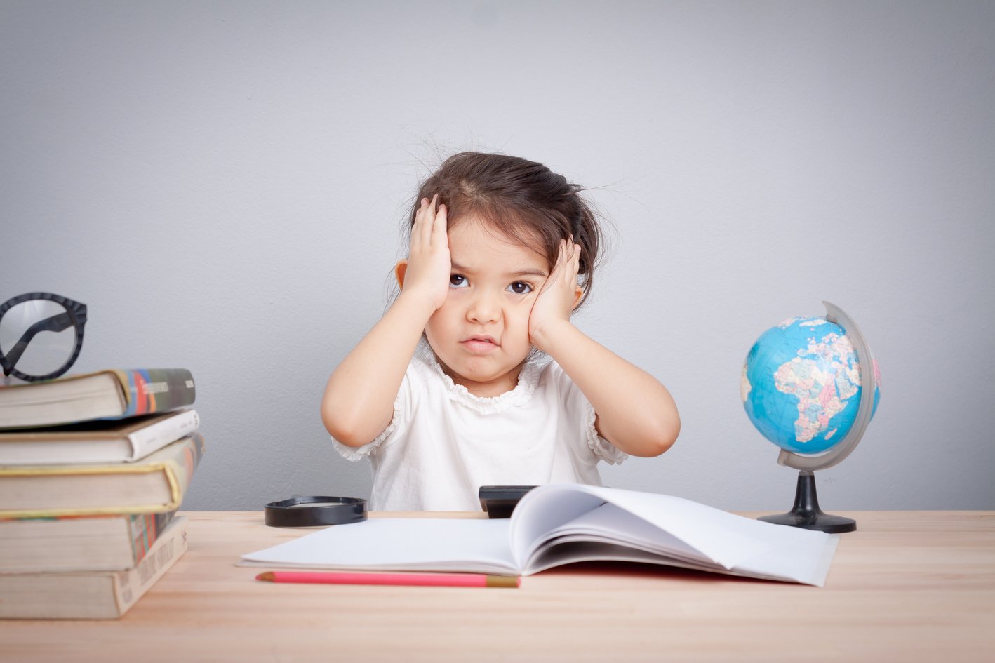 Thinking child bored, frustrated and fed up doing his homework